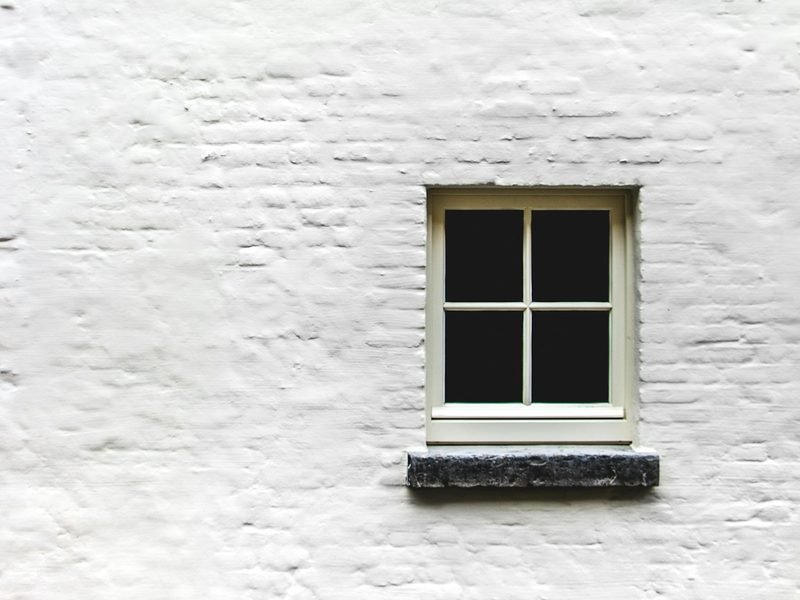 Châssis de fenêtre blanc sur un mur en briques peintes